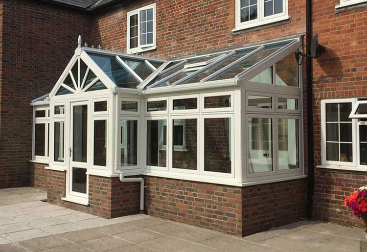 A white t-shaped conservatory for a home in Dorset.
